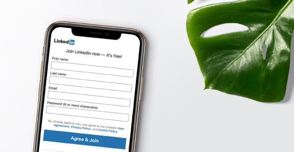 Smartphone lying on a table with the LinkedIn login page on the screen