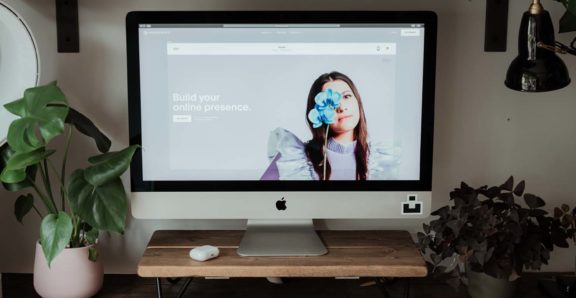 A computer sitting on a desk with squarespace on the screen
